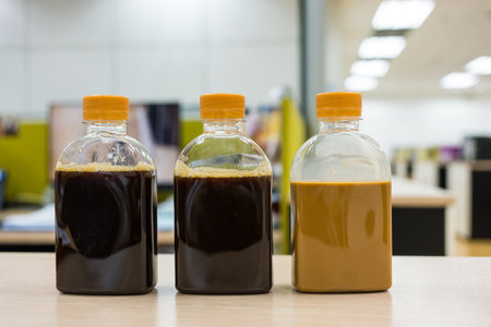 A one bottle of ice black coffee and two coffee latte bottles. Refreshing cold beverage a crisp and energizing taste in clear plastic bottle. A order from online delivery.の写真素材