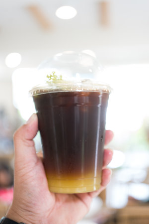 Yuzu Americano on man hand with blur background. Close upの写真素材