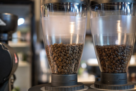 Grinder coffee machine. Coffee beans inside the machine hopper of coffee shopの写真素材