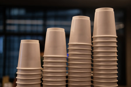 White paper coffee cup for hot drink stacking in rows above coffee machineの写真素材