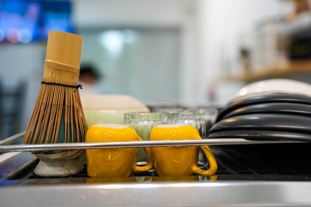 Ceramic cup, dish and bamboo matcha tea whisks on coffee machine at coffee shop.の写真素材