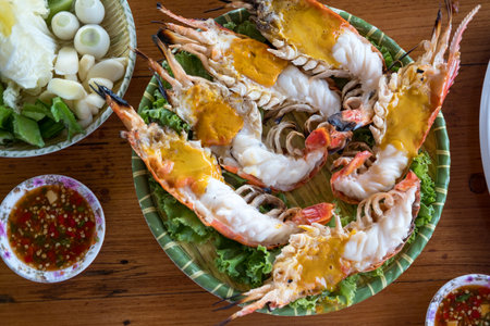 Large river prawns are grilled on a charcoal stove. The head of the shrimp is served on platesの写真素材