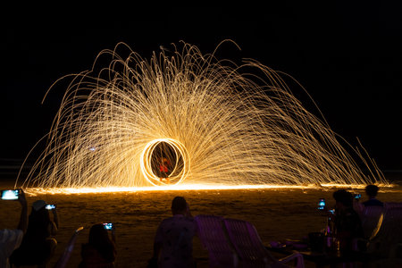 Fire poi in action by a male performance on the beach at Thailandの写真素材