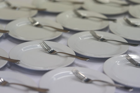 Close up of many empty clean small plates and fork for coffee or tea and desserts in hotel or restaurant. Coffee brake in office.の写真素材