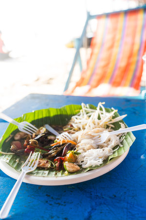 Leftover after eat of Thailand spicy papaya salad on blue table at the beachの写真素材
