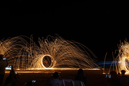 Dancer show swimg the fire of steelwool on the beach in party near bar and restaurant in Thailand
