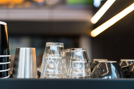 Clean shot glass and ceramic coffee cups lie upside down on a coffee machine in a cafe. Close up. Selective focus.の写真素材