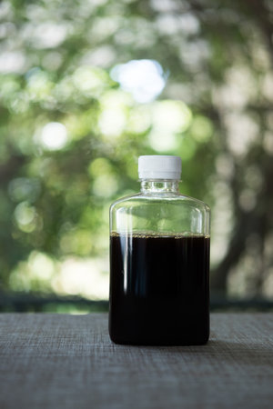 Bottled iced coffee is placed on table against nature background.の写真素材