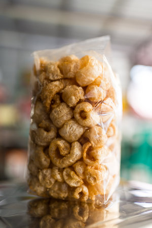 Pork rind or pork scratching without fat caps in a clear plastic bag is an snacks basedの写真素材
