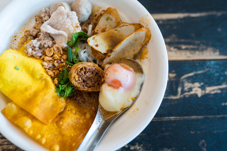 Delicious spicy tom yum noodle soup with pork with many toppingの写真素材