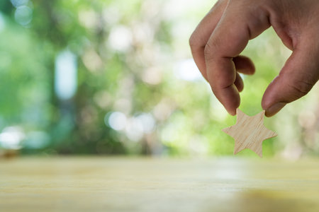 Star sharp wood in man hand against nature background with copy space.の写真素材