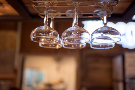 Clean glasses hanging upside down above a bar rack in restaurant.の写真素材