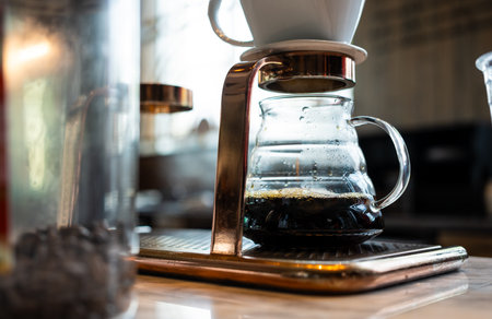 Alternative coffee brewing method, using pour over dripper and paper filter. Barista making a drip...