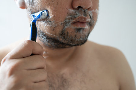 Asian adult men shaving the beard in homeの写真素材