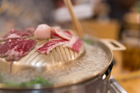 Use wood chopsticks put beef on a yellow brass panの写真素材