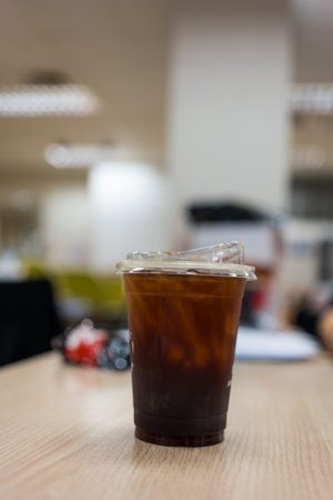 Iced coffee in cup on wood office desk during business work conceptの写真素材