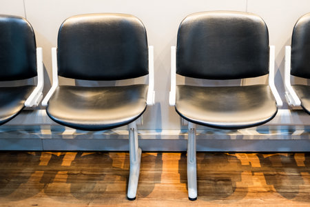 A row of chairs in a waiting room, empty chairs