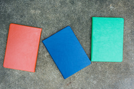Closeup shot of a row of three leather covers on a stone background