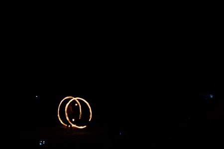 Amazing impressive light fire show with fire trails on the beach in Thailand