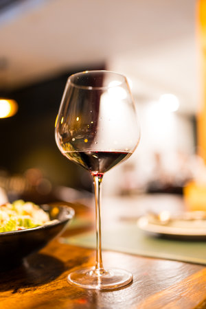 A glass of red wine on a dinner tableの写真素材