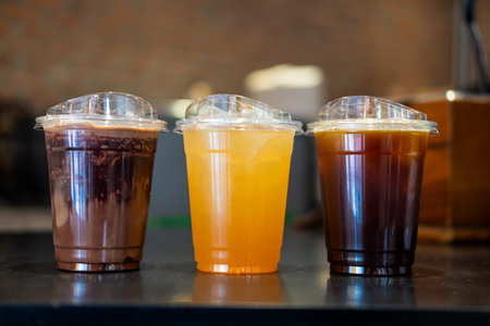 Three plastic cup of iced black coffee, iced Mocha and iced tea at cafe.の写真素材