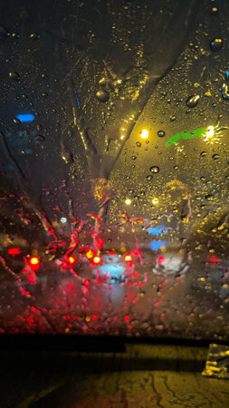 On rainy nights, the rain-covered window glass reflects the city lights and forms colorful abstract...