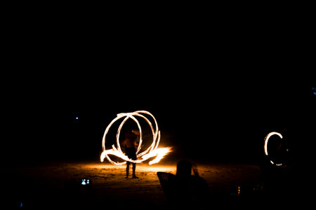 Fire show man in night dances on long exposure in Thailand.の写真素材