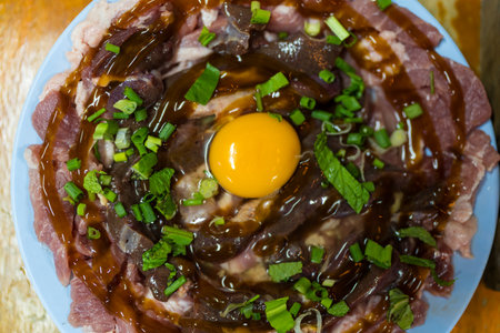 Marinated pork and beef with egg yolk on center of dish ready to cook, Thai food, Chim chum.  It is the Northeastern food of Thailand.の写真素材