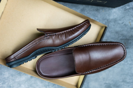 Pair of fashionable stylish brown loafer shoes on paper boxの写真素材