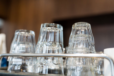 Clean glass cups lie upside down on a coffee machine in a cafe. Close up and selective focusの写真素材