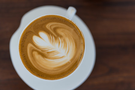 Close up of professional latte art showing milk foam latte art with leaf details on hot coffee cupの写真素材