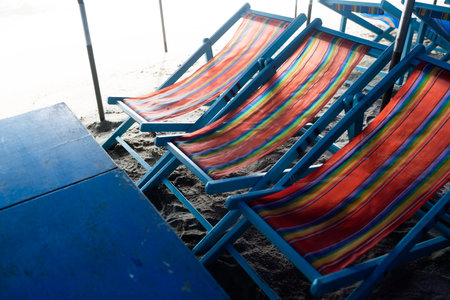 Empty of beach chairs with blue table under umbrellaの写真素材