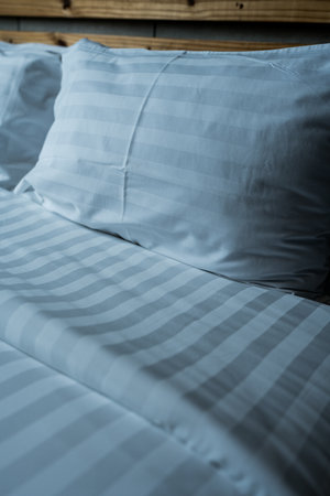 Close up of white pillow on white bed