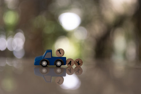 Tax text written on wooden block to climb on toy car with copy space, vintage tone. Business accounting and tax concept.の写真素材