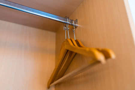 Empty wooden clothes hangers in hotel room with copy spaceの写真素材