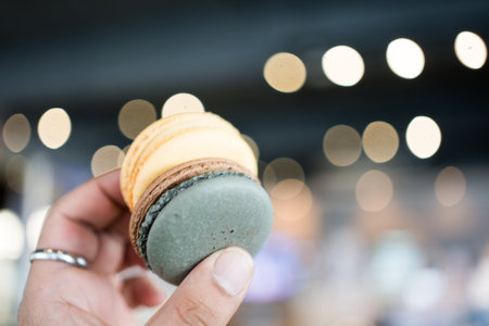 Closeup of macarons sweet chocolate and lemon flavors on handの写真素材