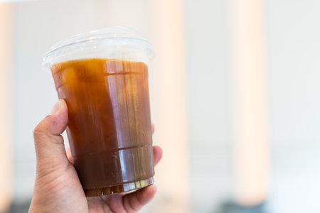 A cup of iced americano coffee in handの写真素材