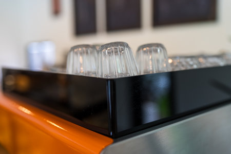 Glass coffee cups lie upside down on a coffee machine in a cafe, selective focusの写真素材