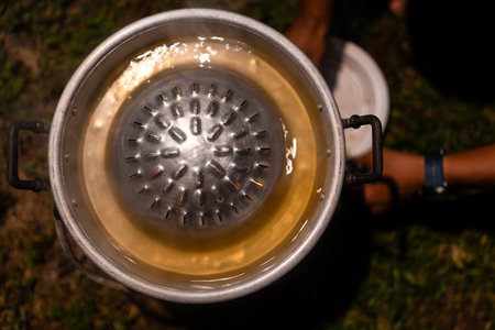 Empty metallic BBQ pan set on charcoal stove at the campingの写真素材
