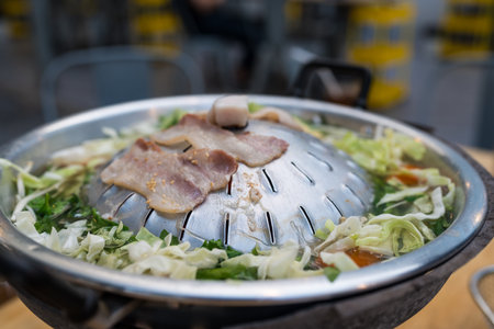 Meats on a hot frying pan, eating Thai style barbecue. Its name is called Moo Ka Ta, a popular food...