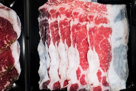 Thinly sliced of raw beef on tray prepare for customer cook. Japanese hot pot also known as Shabu Shabu or Sukiyaki is Japanese style is popular local food in asian countries.の写真素材