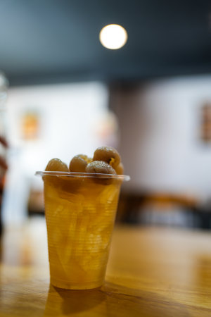 Longan juice fresh drink water in the plastic glass on wood table.