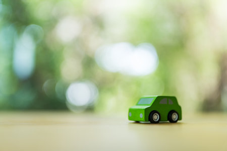 Green wooden toy car on wood table, vehicle eco friendly natural wood materialの写真素材