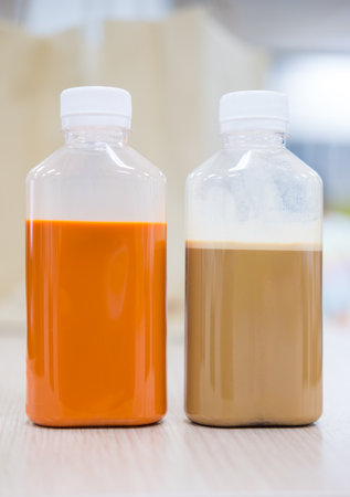 Thai milk tea and coffee in plastic bottles with white lid on table at officeの写真素材