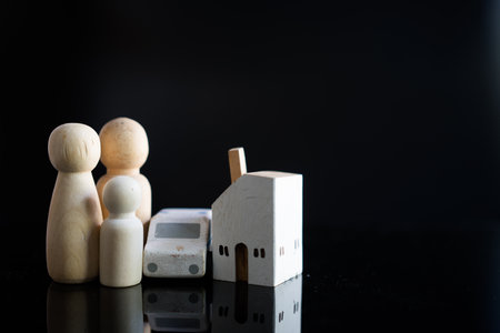 Wooden human family figure peg dolls with home and car. Money saving concept to build a family, marriage, family planning. Reserve money for future use of life partner. Success familyの写真素材