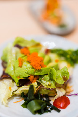 Fresh avocado salad is served in a plate, topped with egg shrimp. Healthy vegetable dietの写真素材