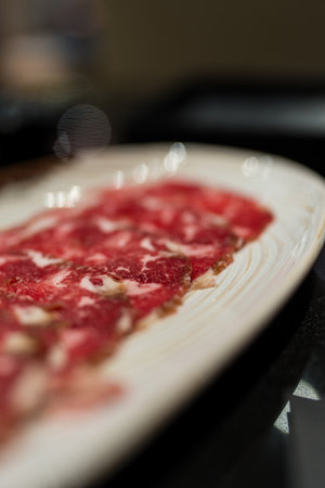 A white plate of raw beef slices ingredient in hot pot restaurant.の写真素材