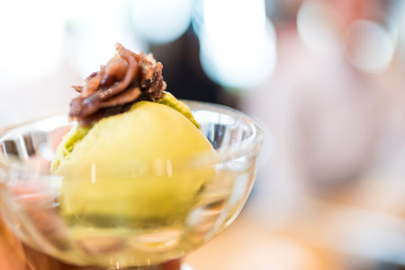 Matcha ice cream topped with red bean paste served on glass bowl
