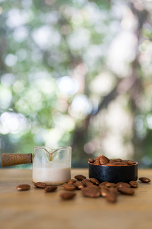 Glass fresh milk and many of Almonds nut in small bowl on wooden table with copy spaceの写真素材