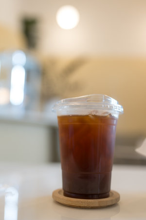 Iced americano coffee on wood coaster in coffee shop.の写真素材